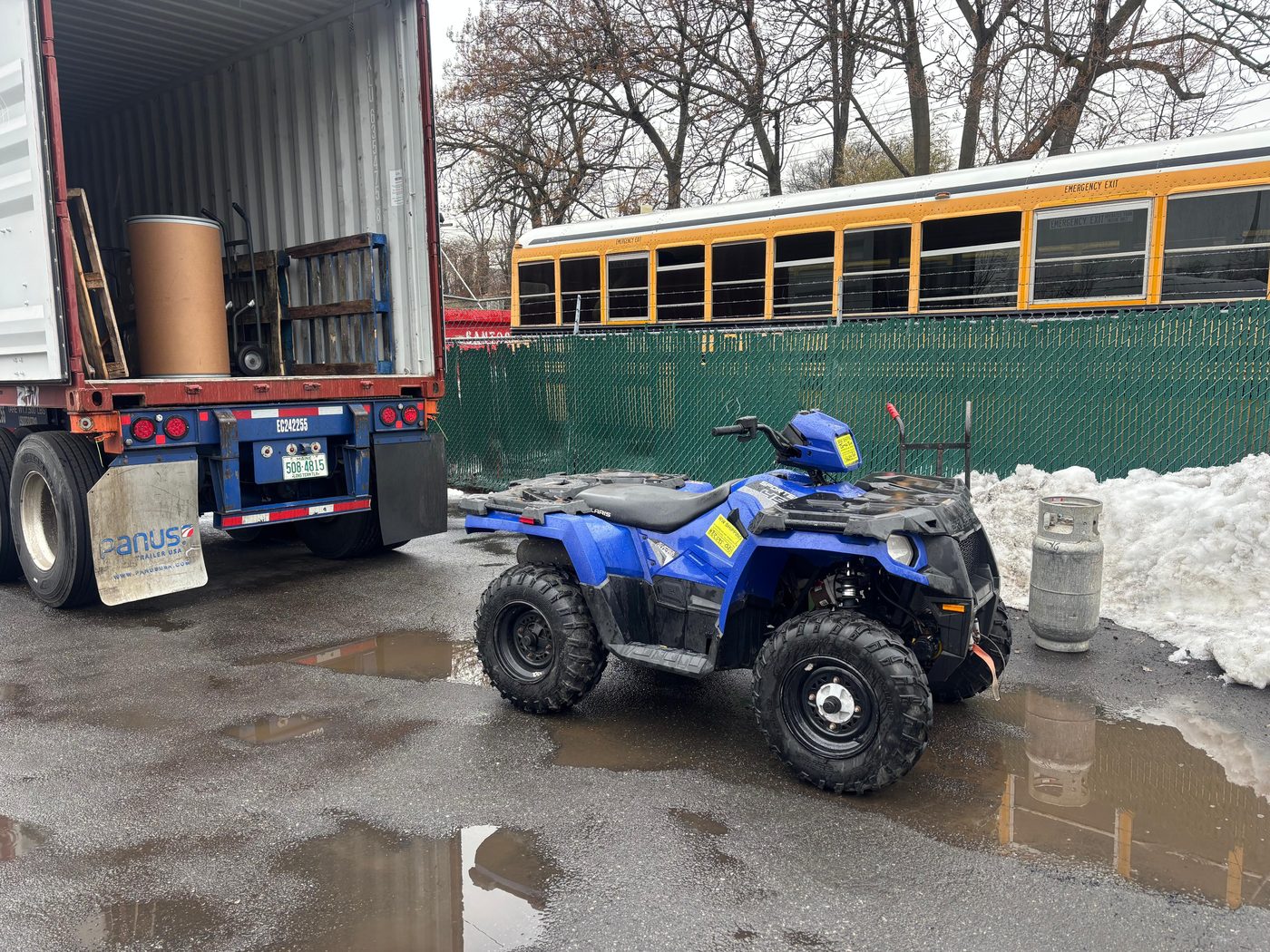Blue Polaris ATV at shipping container
